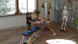 Dr. Justine Bernard works with a client, marking bony landmarks on their back as they sit.